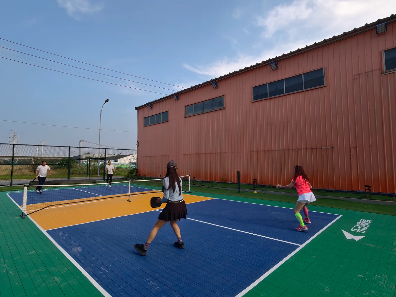 Players using an outdoor pickleball court with interlocking flooring
