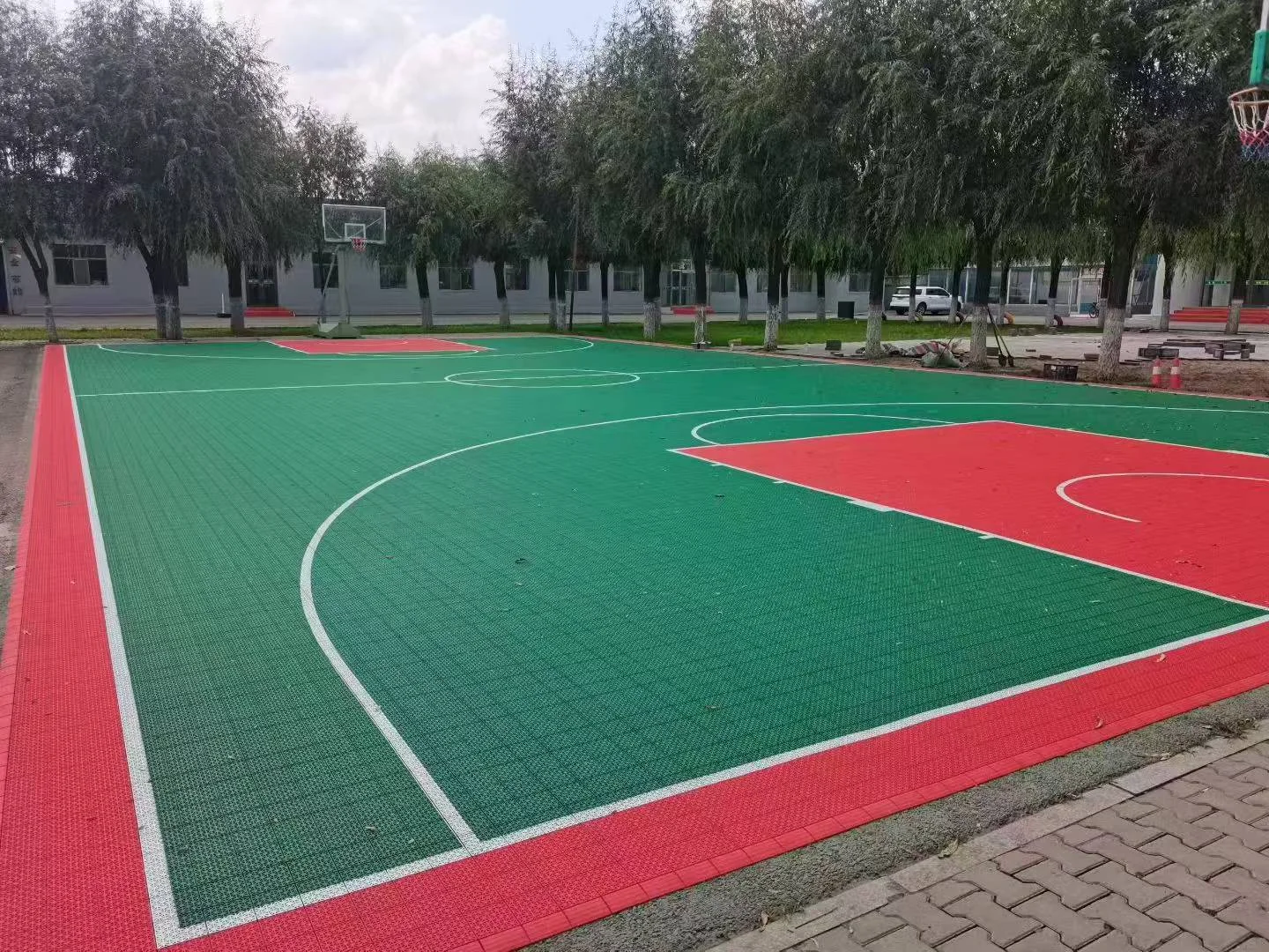 Oblique view of the red-and-green court and adjacent paved edge.